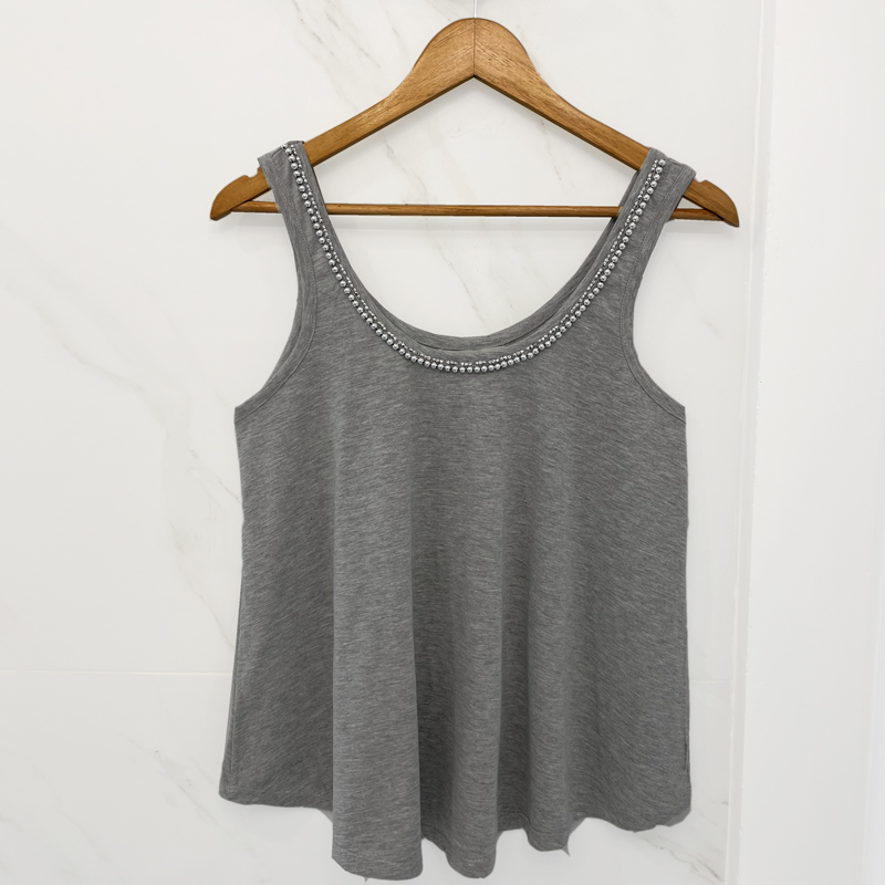 Confeccionada en tejido de algodón, esta musculosa destaca por su elegancia. Su diseño realizado con canutillos y perlas bordada a mano sobre el cuello le agrega un toque de elegancia que te hará destacar en cualquier ocasión.